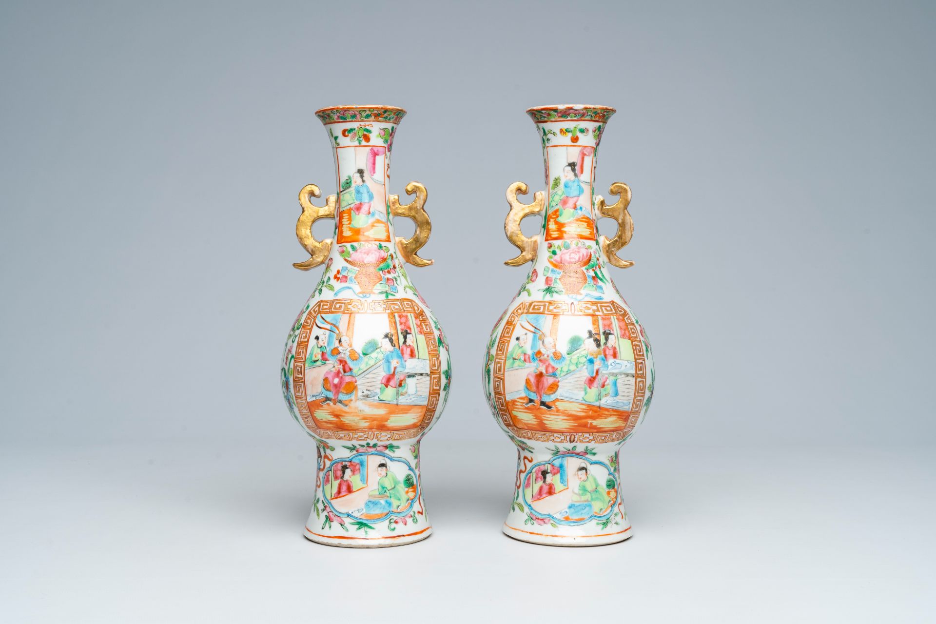 A pair of Chinese Canton famille rose vases and with palace scenes and floral design, 19th C.