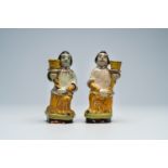 A pair of French polychrome earthenware candlesticks in the shape of a figure with a horn, 18th/19th