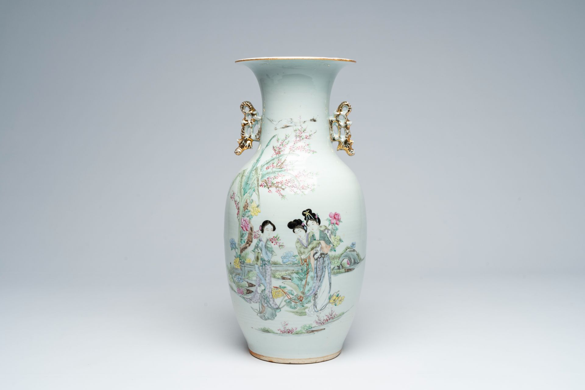 A Chinese famille rose double design vase with ladies in a garden and butterflies among blossoming b