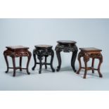 Four Chinese and Japanese open worked carved wood stands with marble and wood top, 20th C.