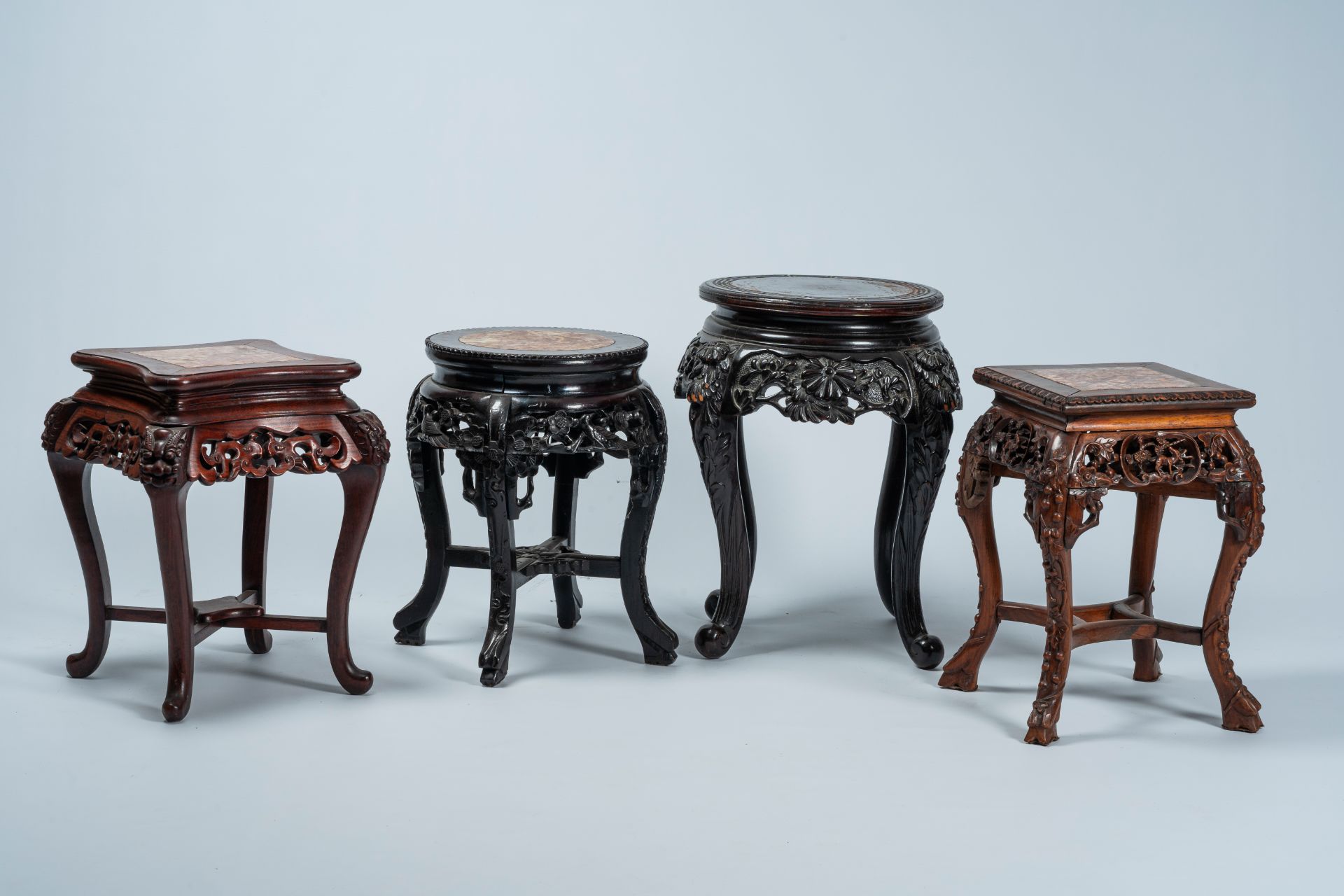 Four Chinese and Japanese open worked carved wood stands with marble and wood top, 20th C.