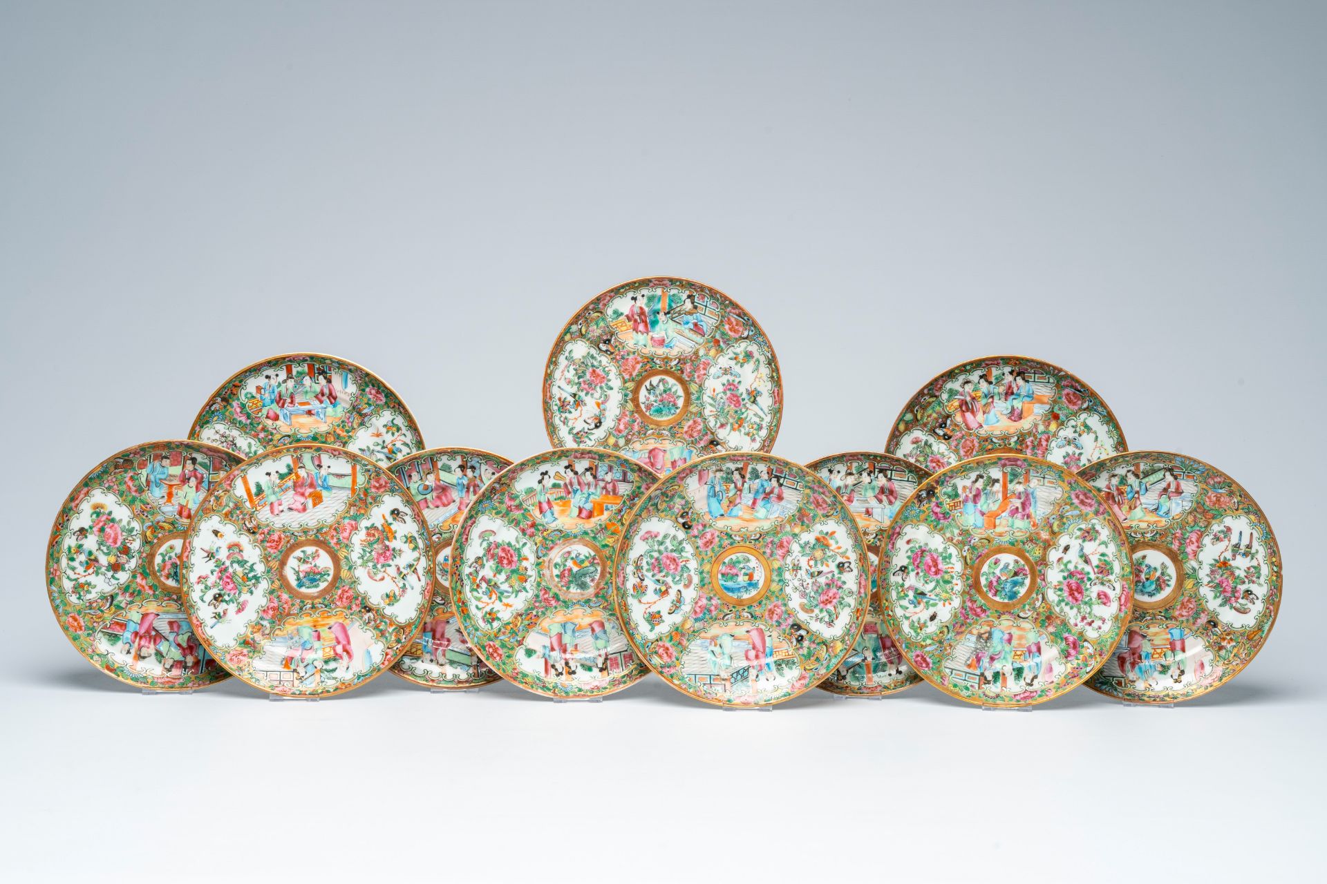 Eleven Chinese Canton famille rose plates with palace scenes and floral design, 19th C.