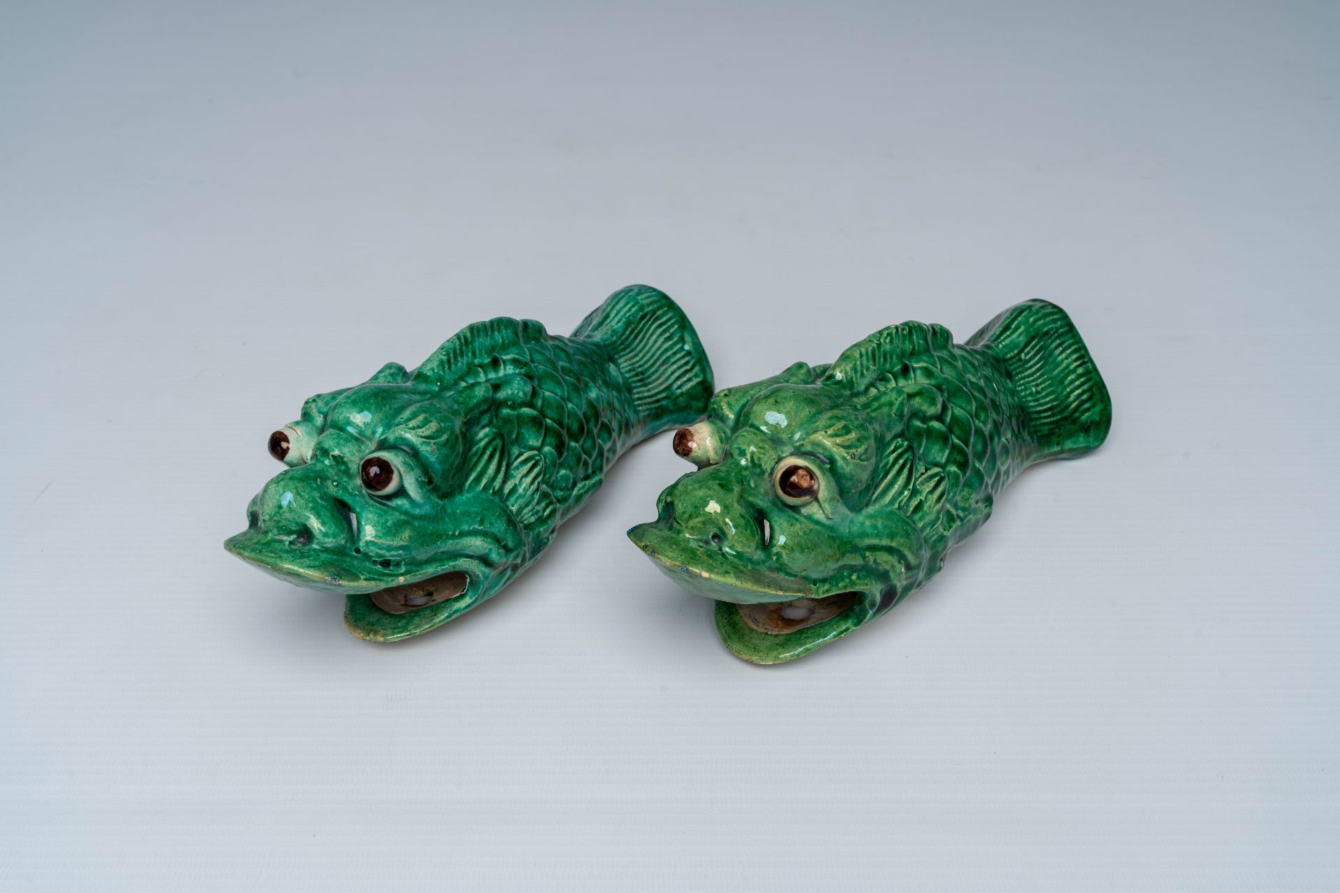 A pair of Chinese green glazed earthenware 'carp' wall vases, ca. 1900