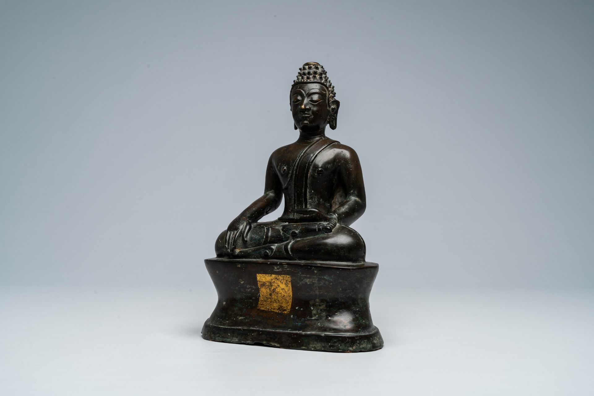 A Thai patinated bronze figure of a seated Buddha, possibly 16th C.