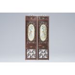 A pair of Chinese open worked carved wood panels with famille rose plaques with a court lady in a la