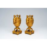 A pair of French gilt bronze vases and covers with bacchantes and lion's feet convertible into candl