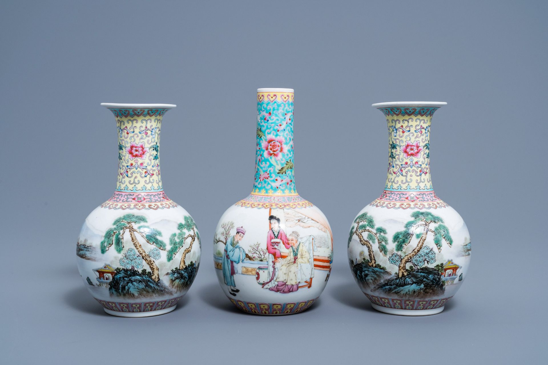 A pair of Chinese bottle shaped famille rose vases with an animated landscape and a vase with figura