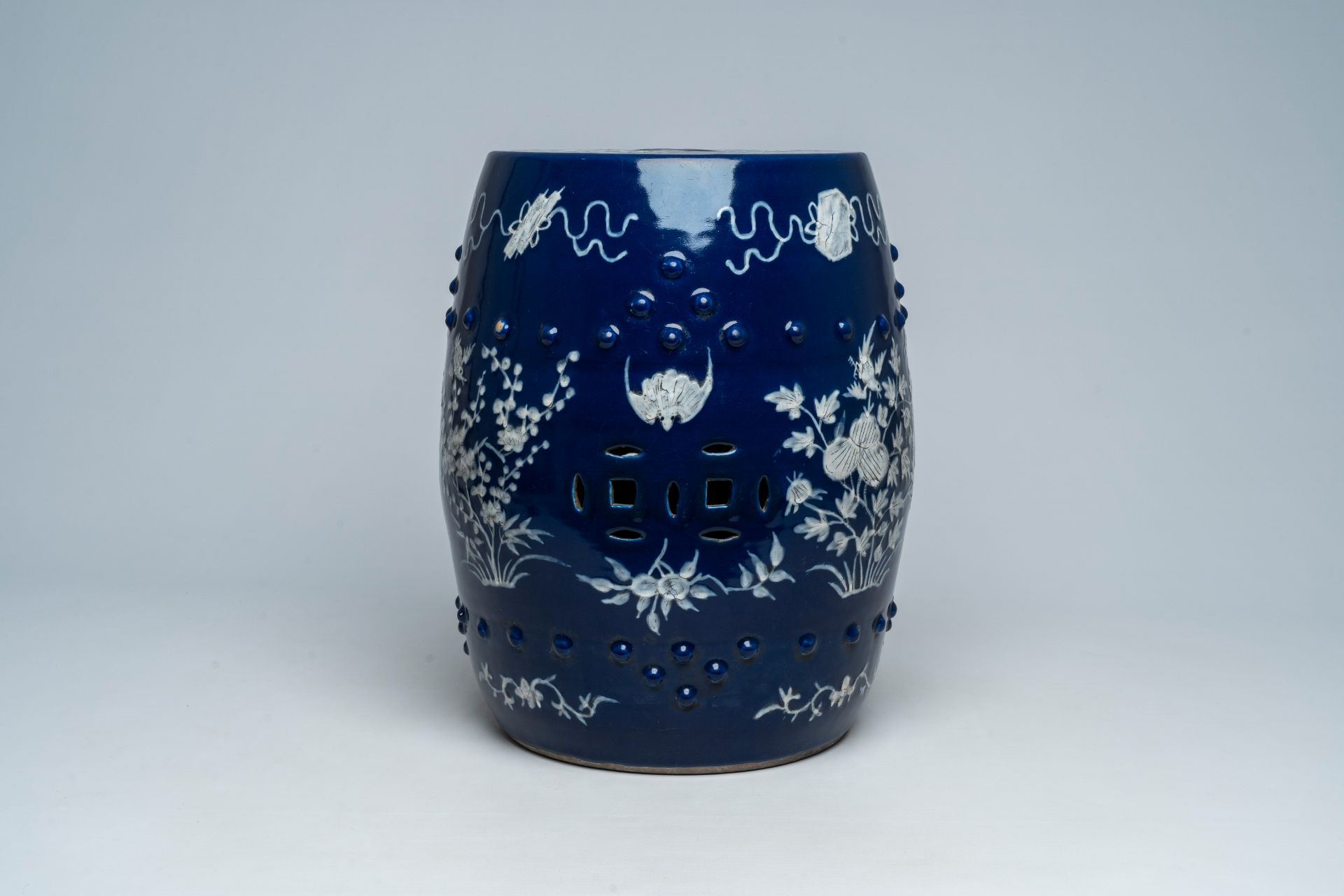 A Chinese slip-decorated blue ground garden seat with floral design, 19th C. - Image 2 of 7