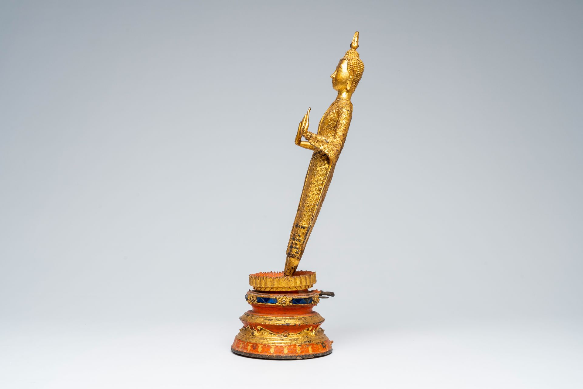 A Thai gilt bronze figure of a standing Buddha on a polychrome painted and glass inlaid metal base, - Image 3 of 8