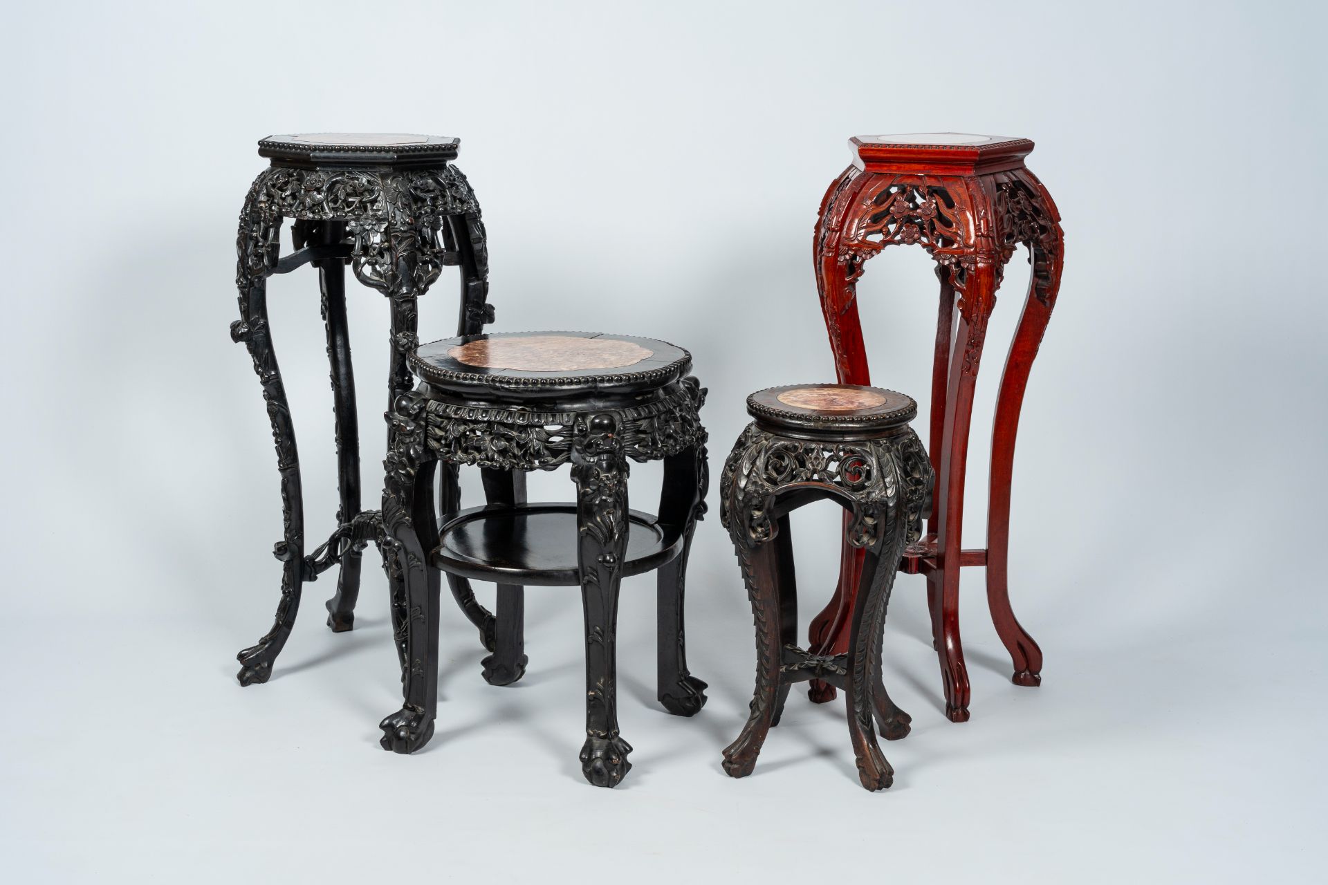 Four Chinese open worked carved wood stands with marble top, 19th/20th C.