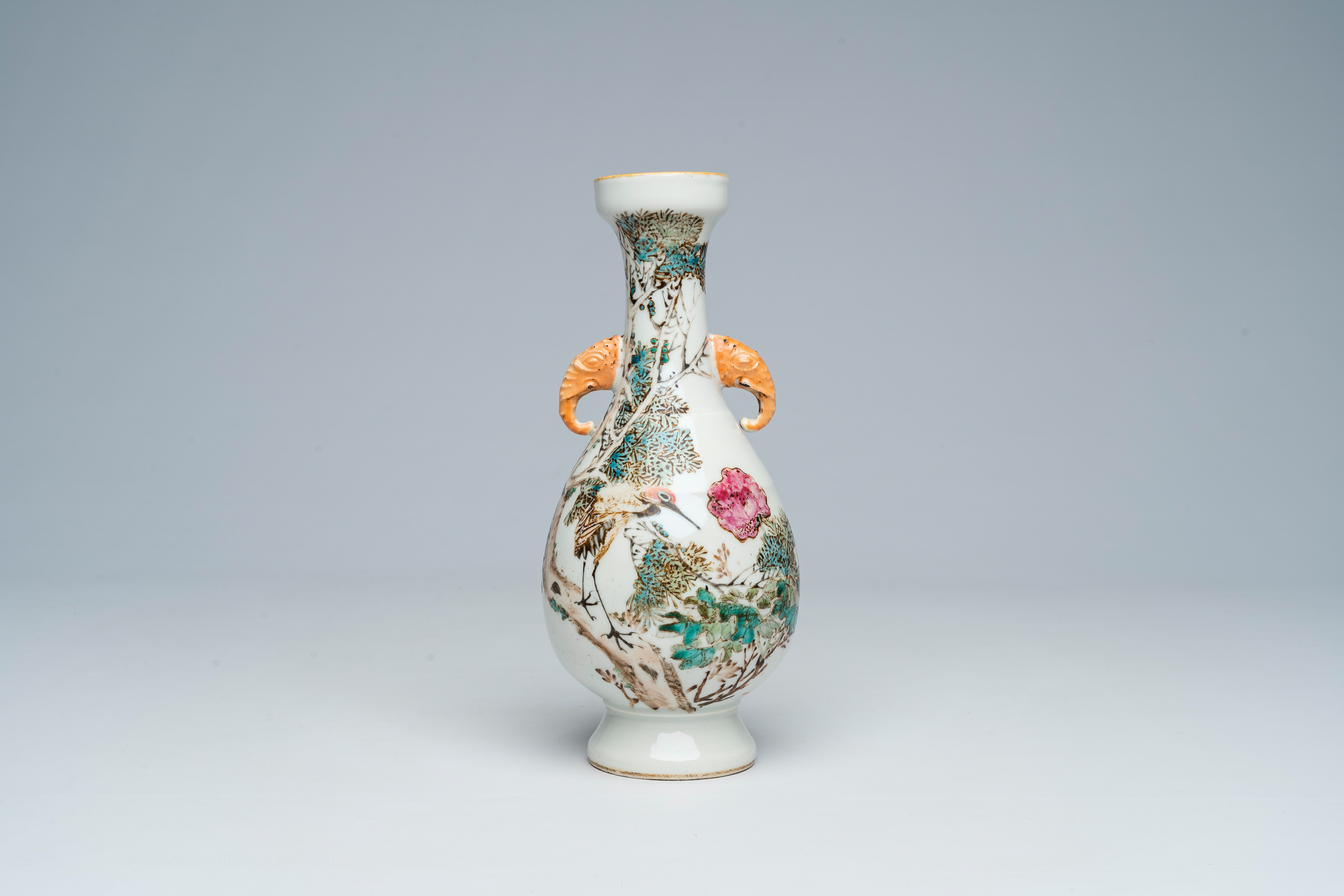 A Chinese qianjiang cai vase with a crane among blossoming branches and elephant head shaped handles