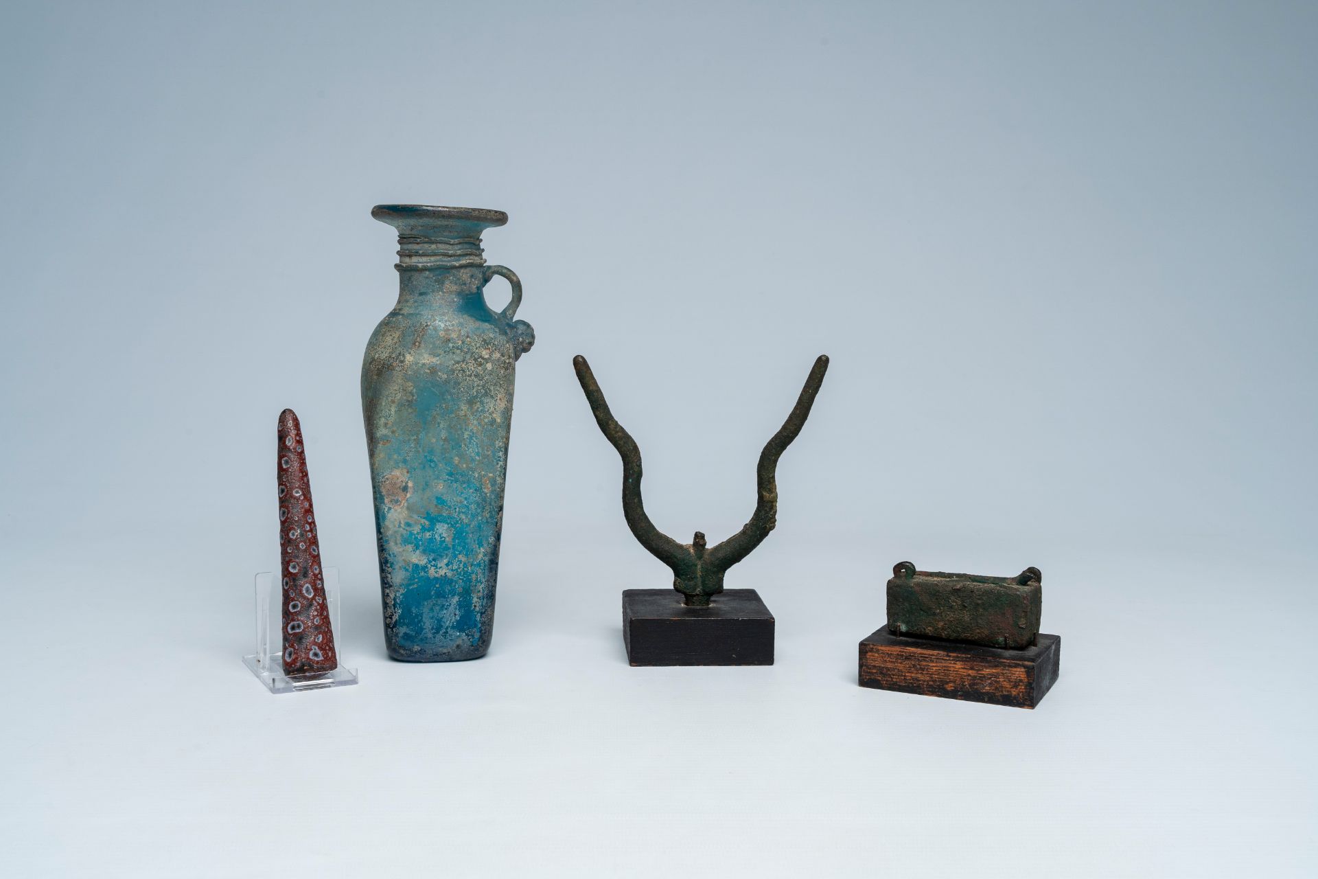 A varied collection of archaeological finds and a blue glass bottle with glass thread design, possib