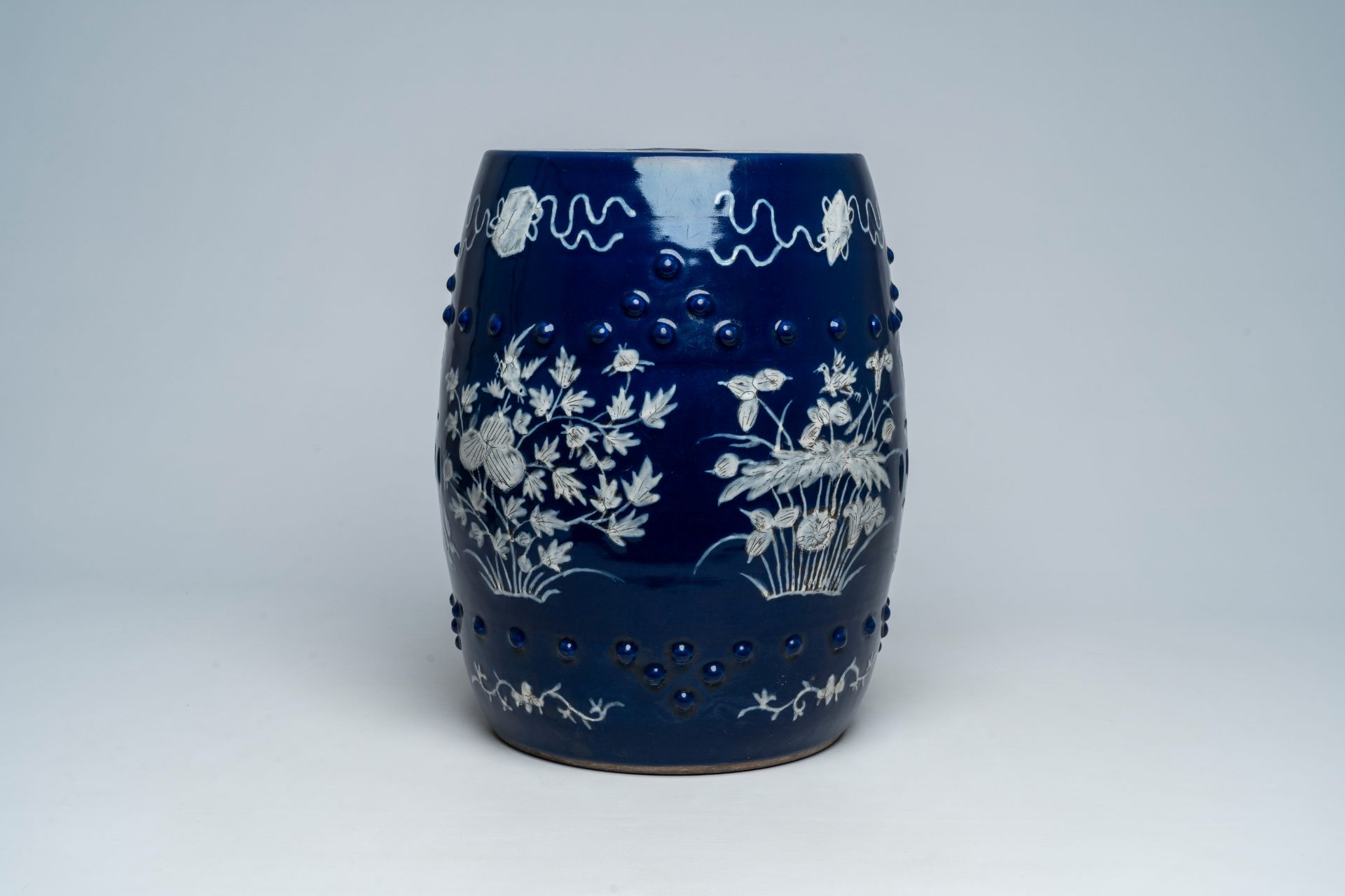 A Chinese slip-decorated blue ground garden seat with floral design, 19th C. - Image 3 of 7