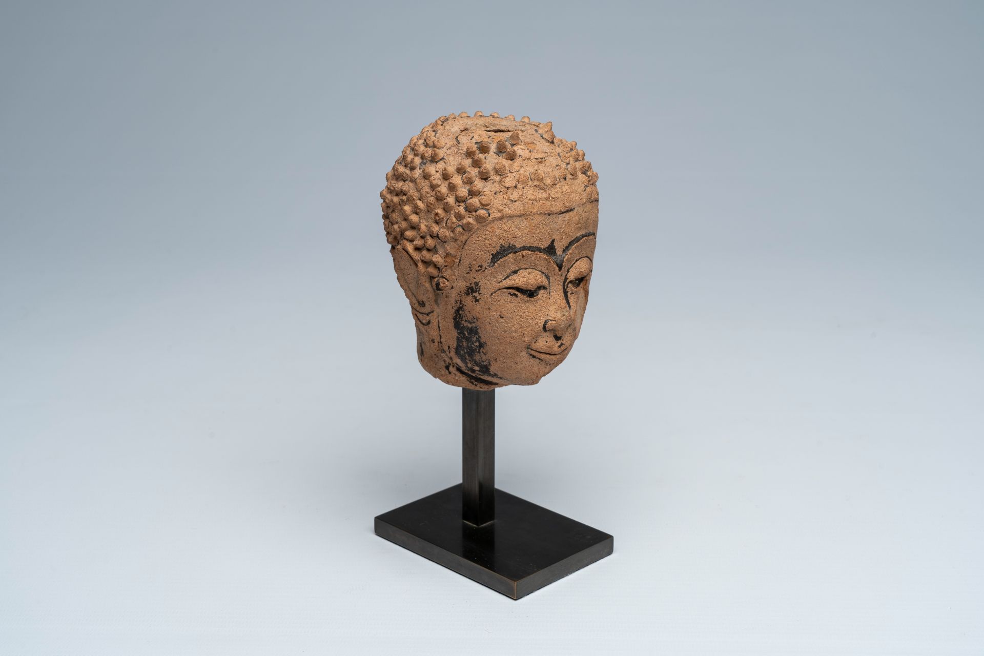 A Thai black ink-heightened pottery head of Buddha, probably Ayutthaya, 16th/17th C.