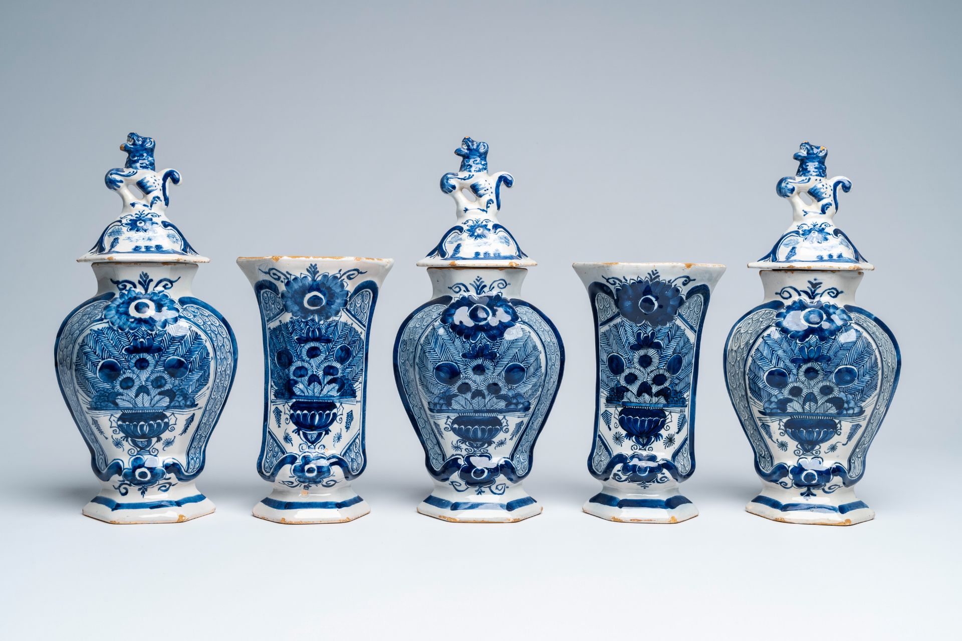 A Dutch Delft blue and white five-piece 'peacock tail' vase garniture, 18th C.