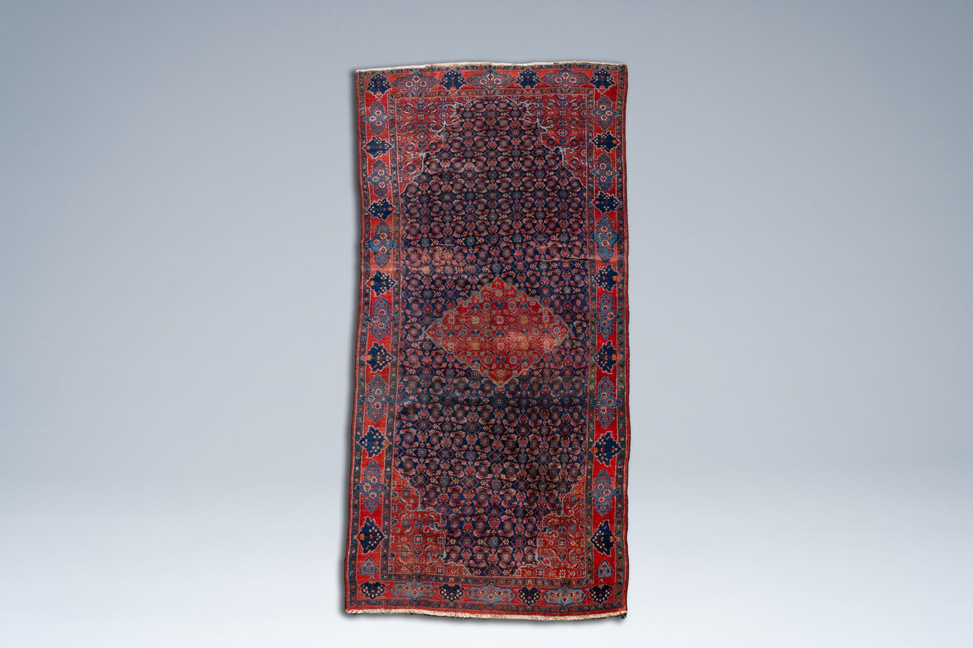 An Oriental Bidjar rug with floral design, wool on cotton, 20th C.