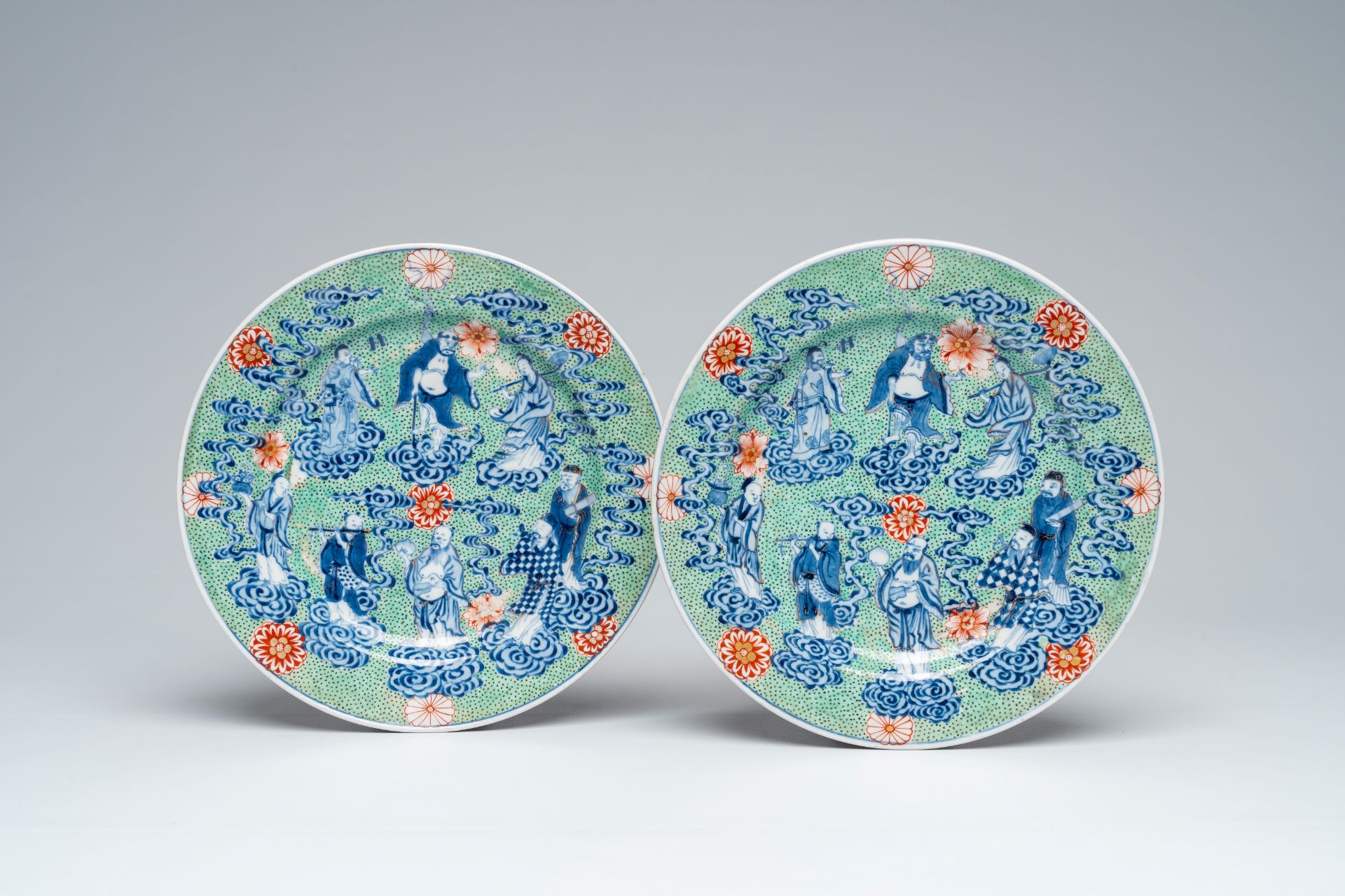 A pair of clobbered Chinese blue and white 'Eight Immortals' plates, Xuande mark, 19th C.