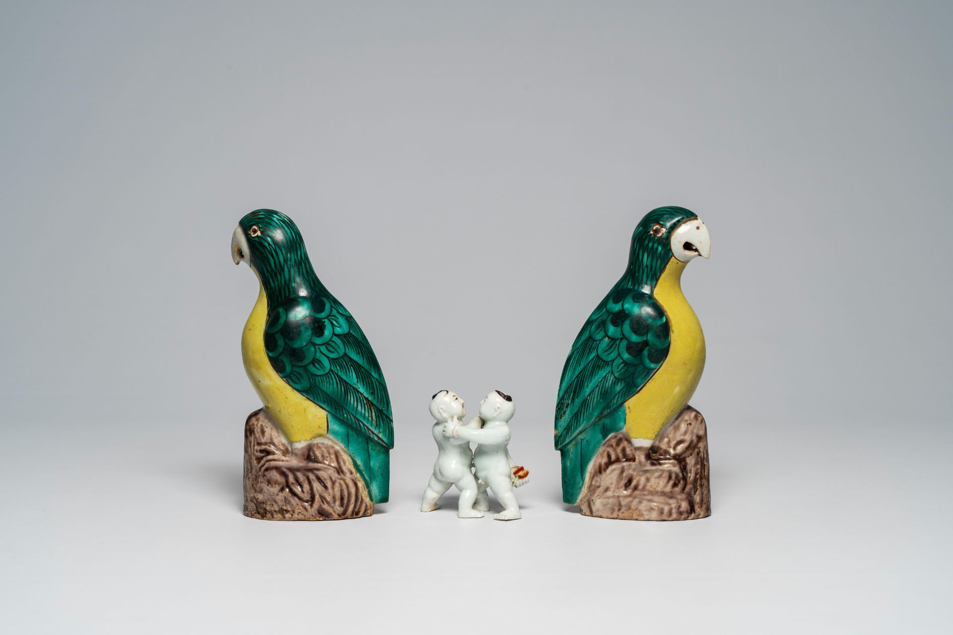 A Chinese polychrome group of wrestling youngsters and a pair of famille verte parrots, 19th/20th C. - Image 4 of 7