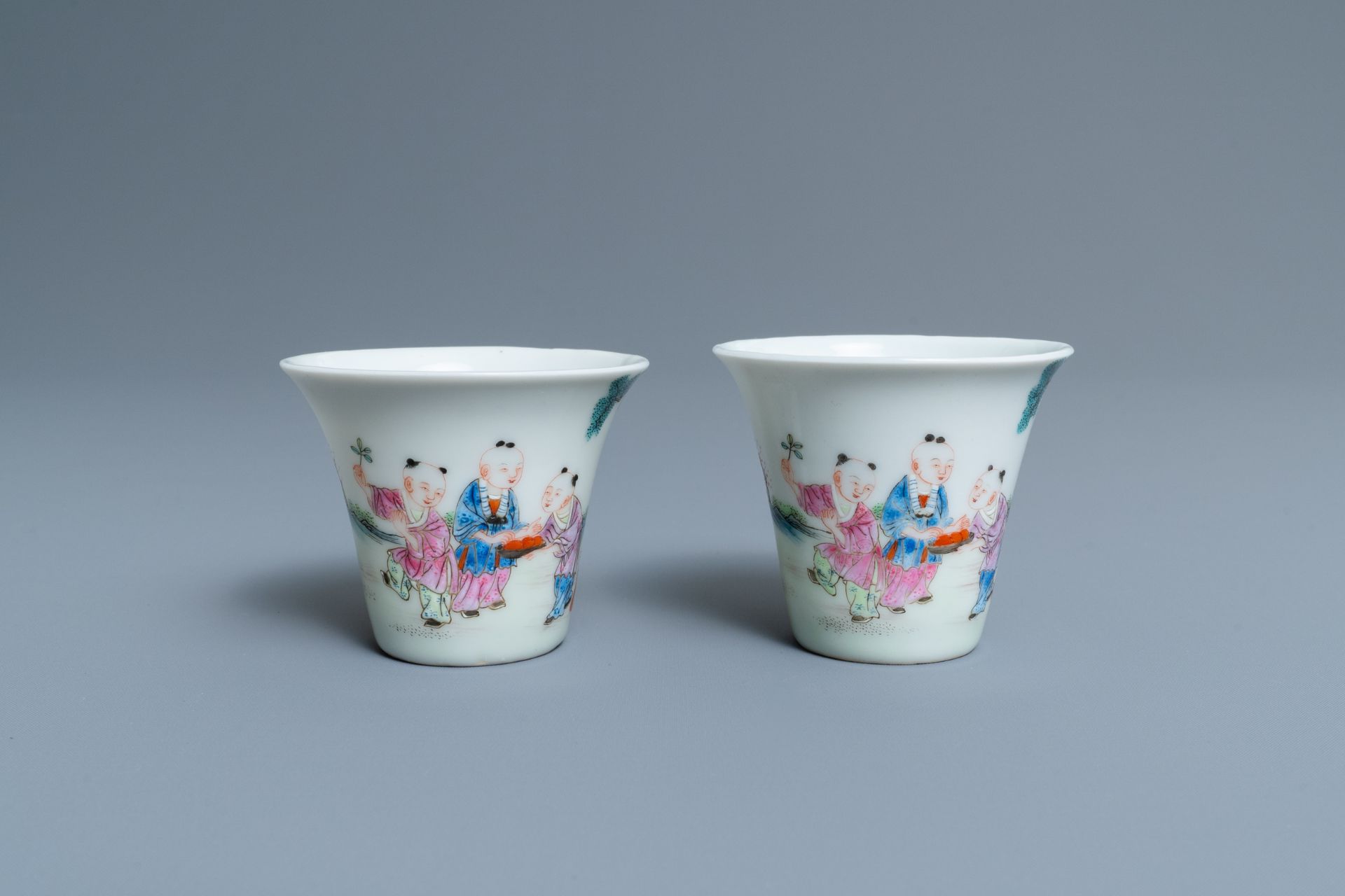 A pair of Chinese famille rose 'playing boys' wine cups, Qianlong mark, Republic, 20th C.