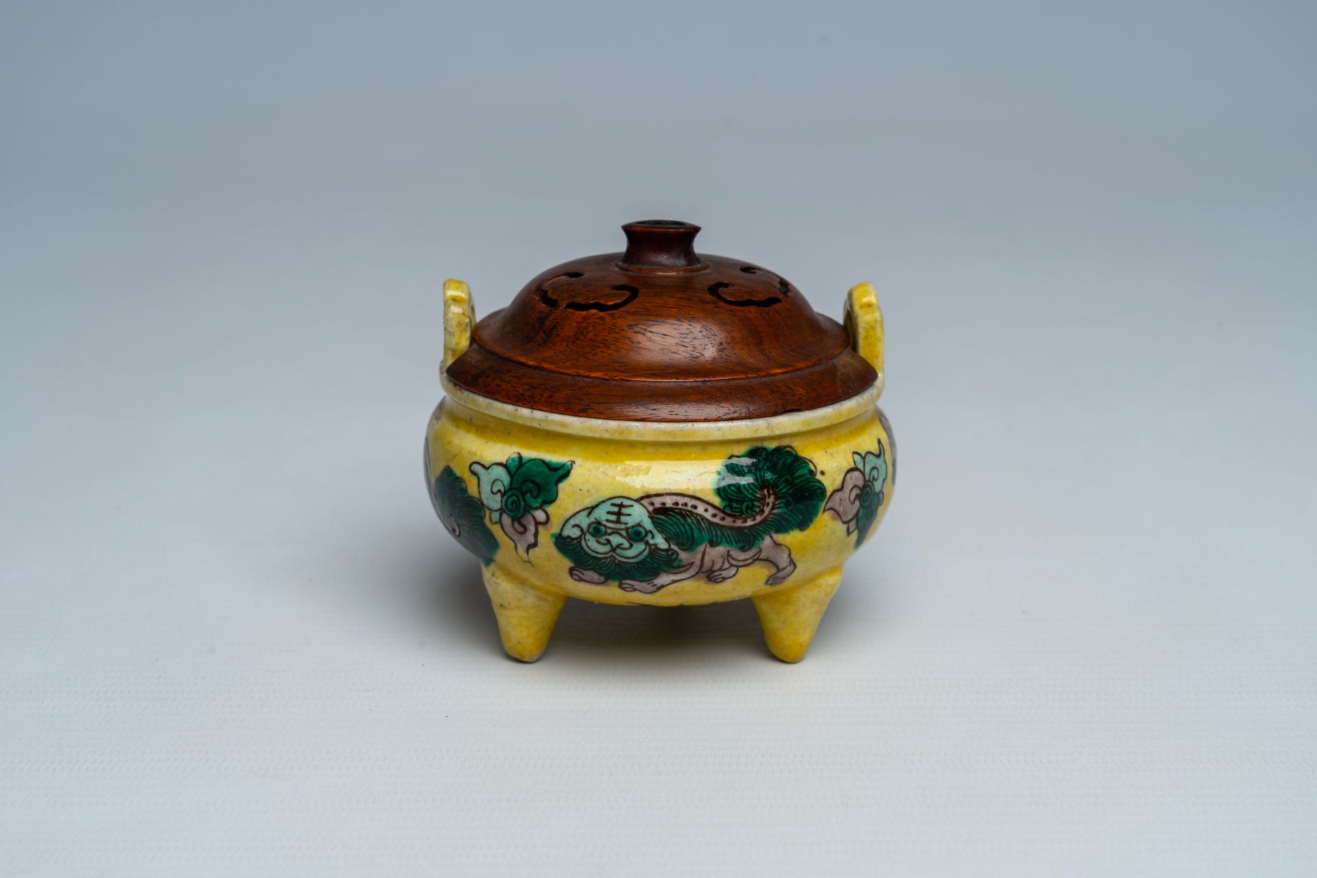 A Chinese verte biscuit yellow-ground 'Buddhist lions' tripod censer, 19th C.