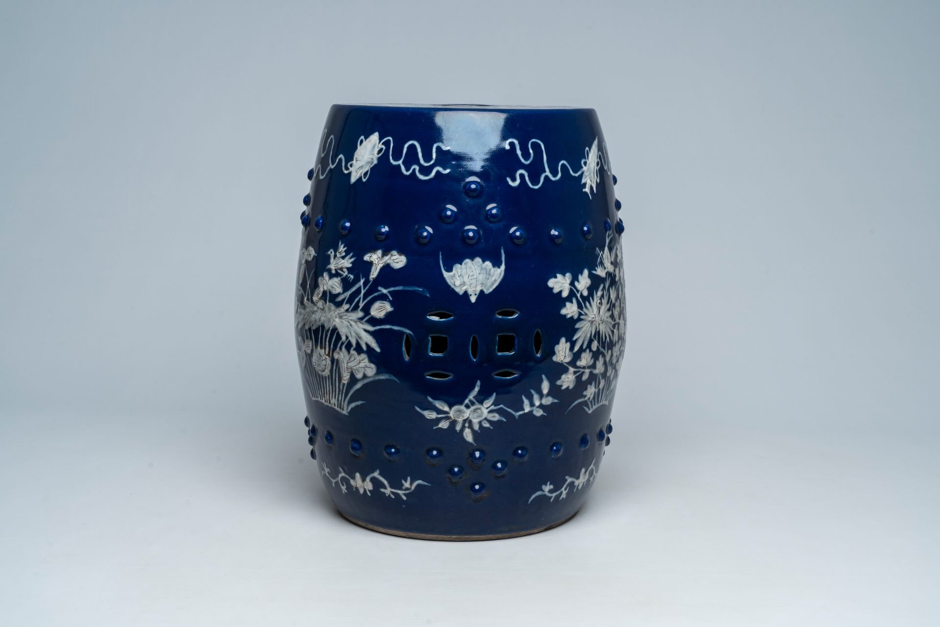 A Chinese slip-decorated blue ground garden seat with floral design, 19th C. - Image 4 of 7