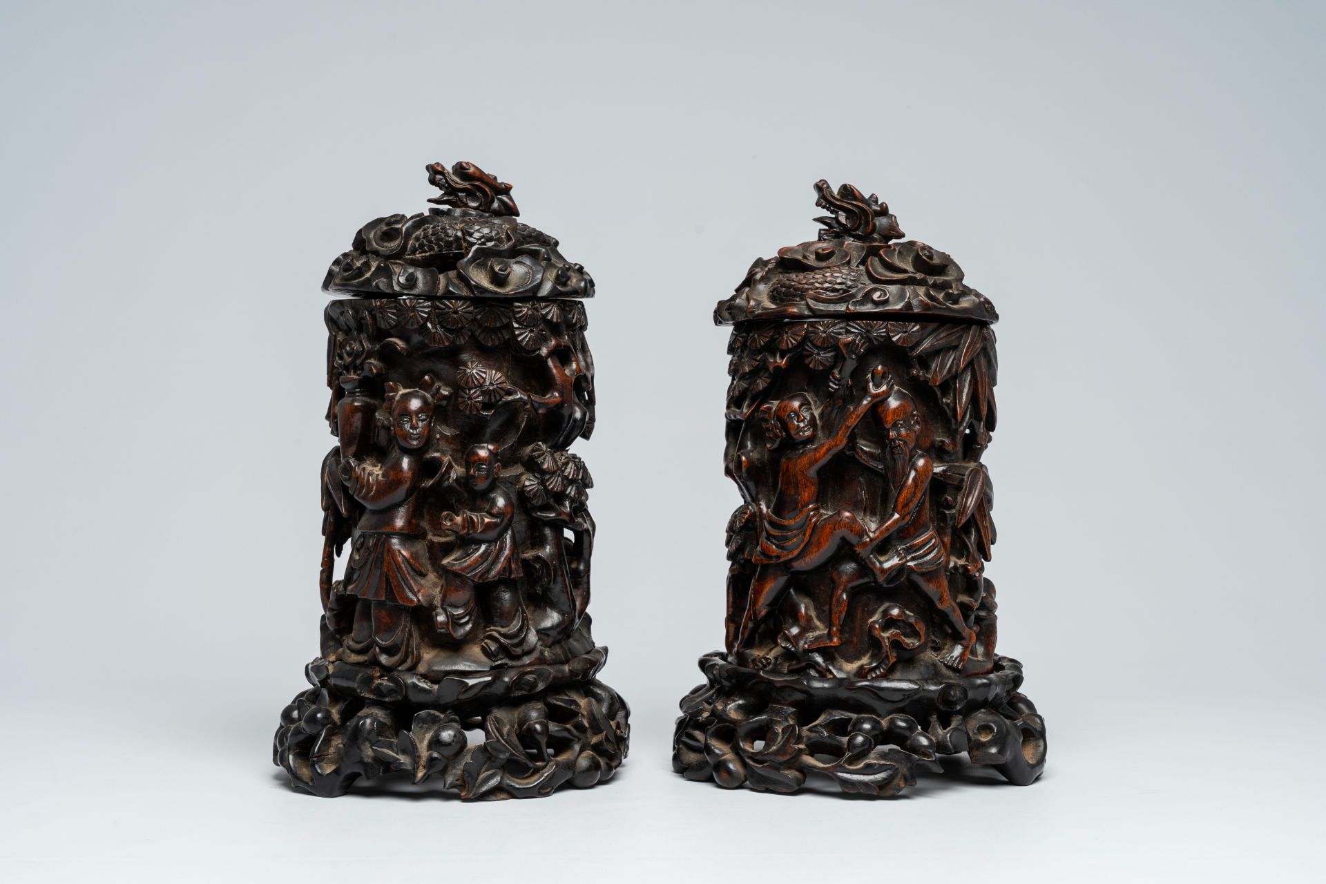 A pair of Chinese wood brush pots with relief design and a pair of open worked stands and covers, 19