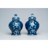 A pair of Chinese blue and white prunus on cracked ice ground vases and covers, 19th C.