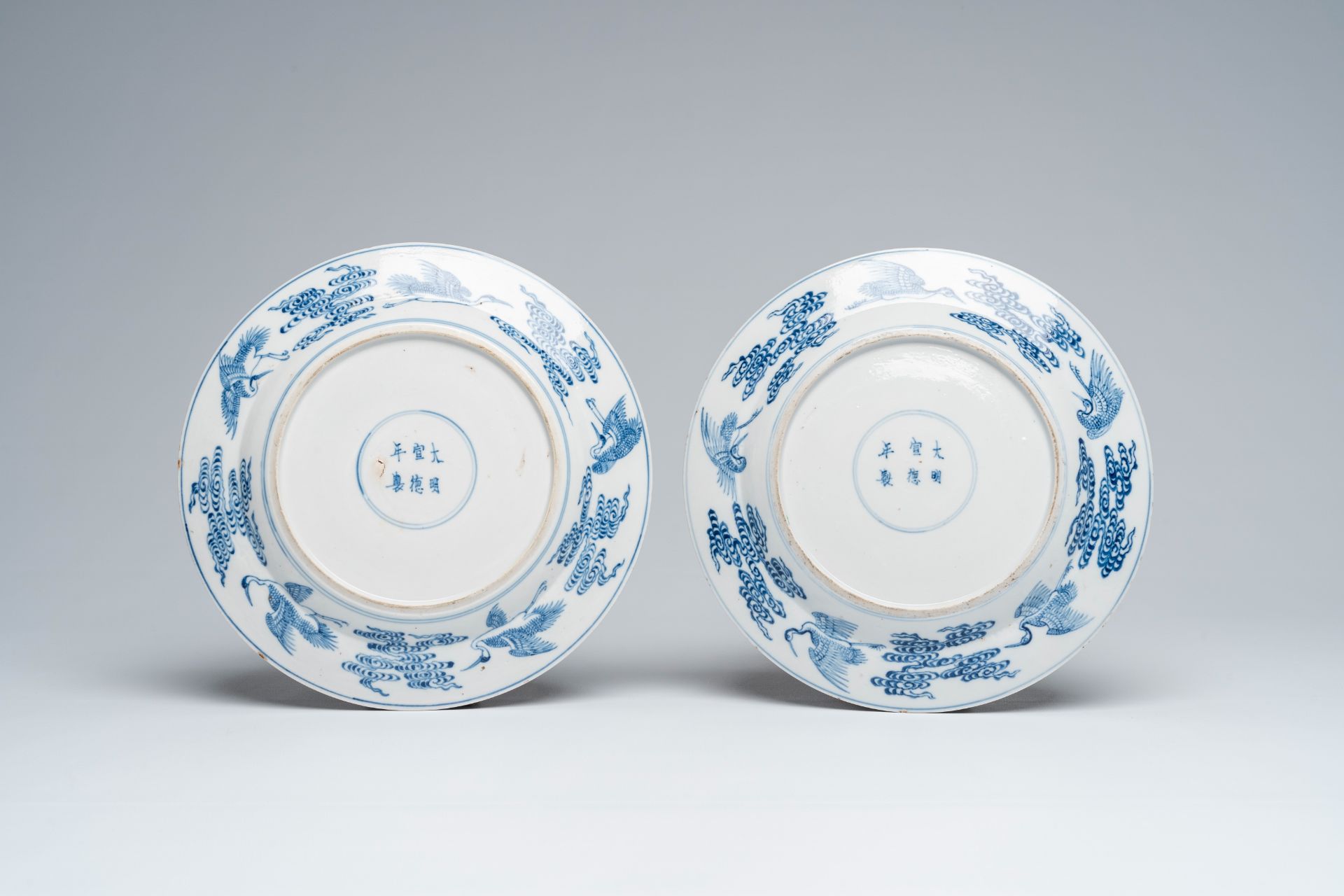 A pair of clobbered Chinese blue and white 'Eight Immortals' plates, Xuande mark, 19th C. - Image 3 of 3