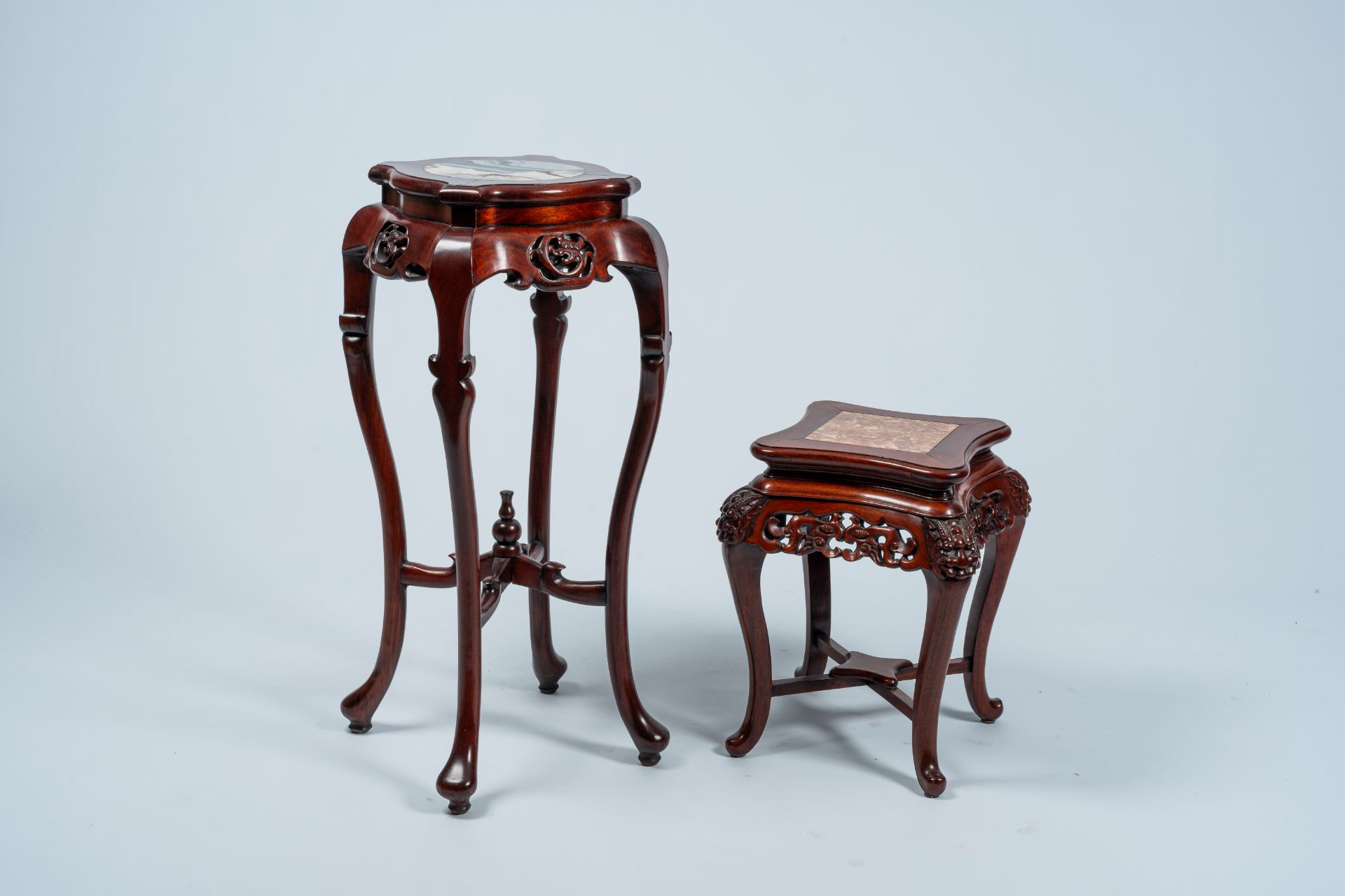 Two Chinese open worked carved wood stands with marble and dreamstone top, 20th C.