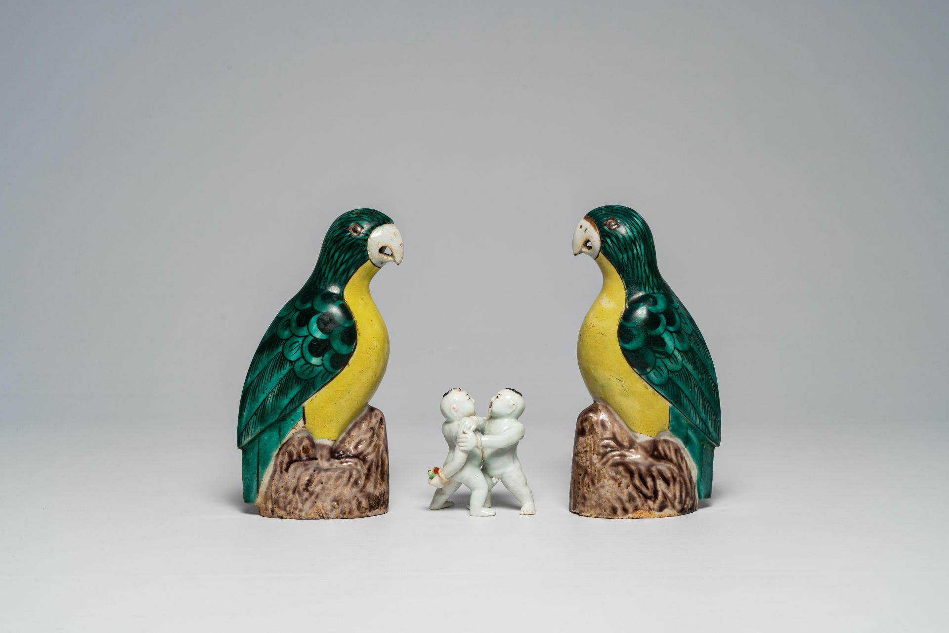 A Chinese polychrome group of wrestling youngsters and a pair of famille verte parrots, 19th/20th C. - Image 2 of 7