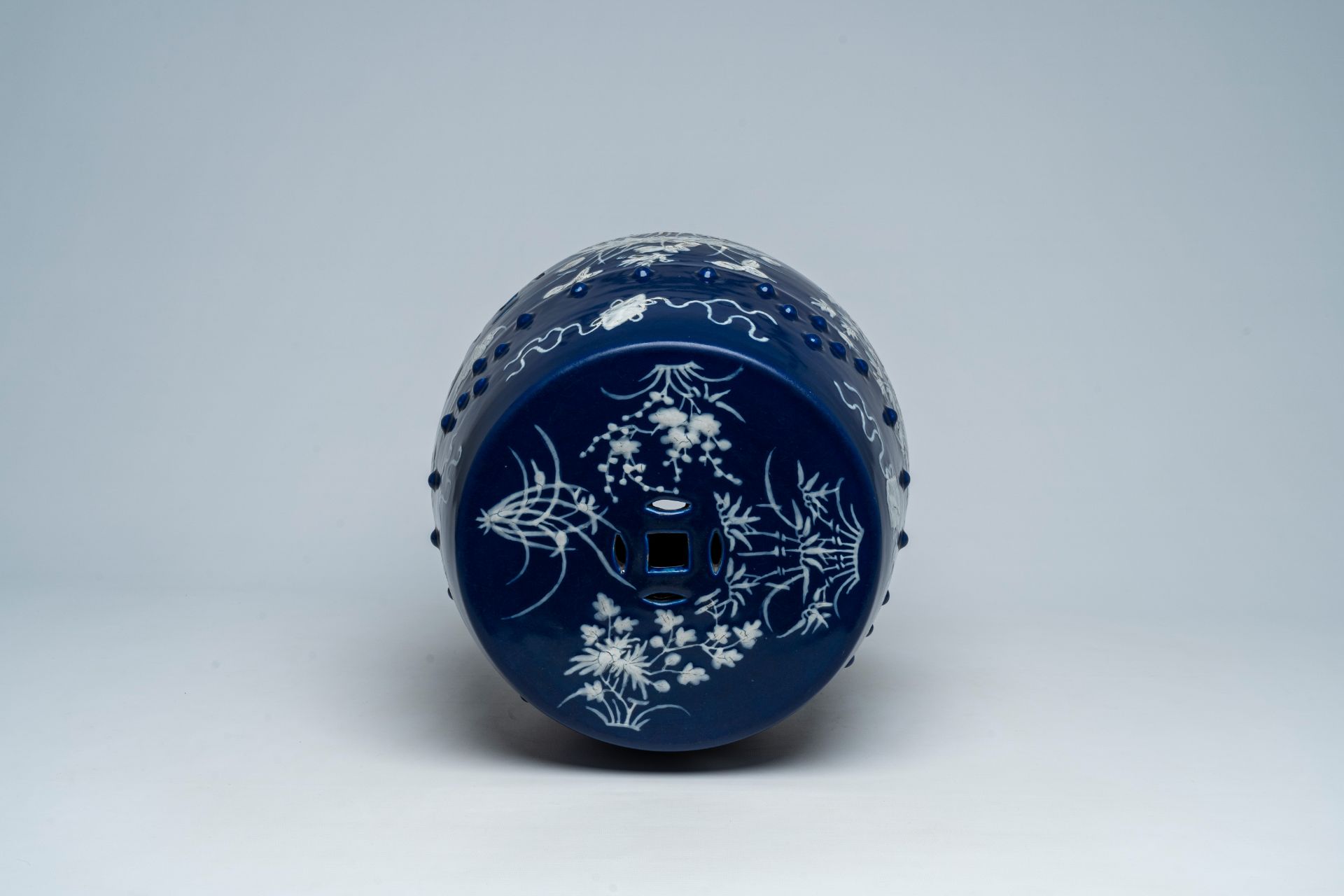 A Chinese slip-decorated blue ground garden seat with floral design, 19th C. - Image 6 of 7