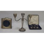 A silver picture frame, a cased set of six spoons and a three light candelabrum, the frame with