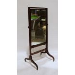 19th century mahogany cheval mirror, on swept ogee supports to brass castors