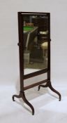 19th century mahogany cheval mirror, on swept ogee supports to brass castors