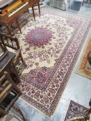 European ivory ground carpet with large central floral arabesque surrounded by floral designs with a