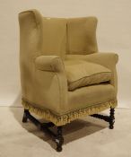 Early 20th century wingback armchair in oatmeal upholstery, turned and block supports and turned