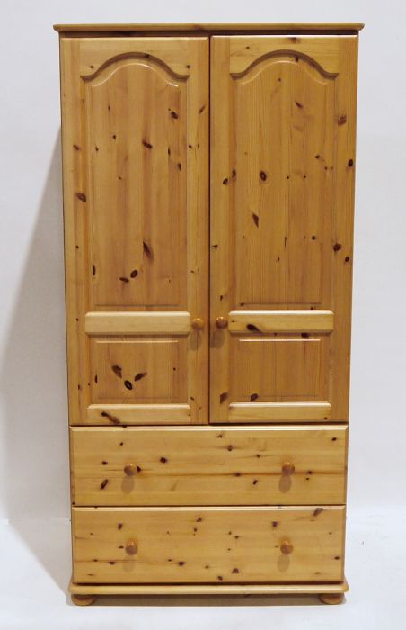 Pair of 20th century pine wardrobes with two cupboard doors and two drawers under, on squat bun feet