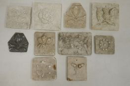 Collection of plaster tiles, each moulded with flowers, leaves/acorns, including a Tudor-style rose,