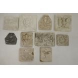 Collection of plaster tiles, each moulded with flowers, leaves/acorns, including a Tudor-style rose,