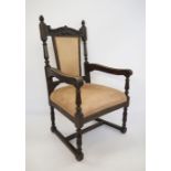 Victorian oak-framed armchair, the carved toprail on fluted arms, turned and block supports,
