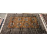 Eastern brown ground rug with two rows of four floral cross motifs, central hooked diamond border