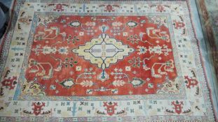 Turkish orange ground carpet with large central floral medallion surrounded by floral decoration,