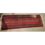 Eastern red ground rug of one row of 22 elephant foot gulls and geometric border 245 x 79 cm