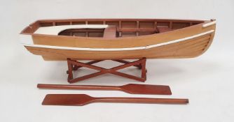 Wooden model rowing boat with oars, the boat 71cm long, on wooden stand