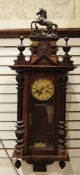 Mahogany and ebonised Vienna-style wall clock with rearing horse surmount flanked by pair urns,
