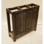 20th century oak umbrella/stick stand with three sections and drip trays, one side with carved