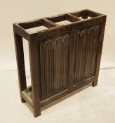 20th century oak umbrella/stick stand with three sections and drip trays, one side with carved