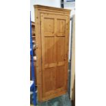 Pine floor-standing corner cupboard with panelled door opening to reveal shelves, on plinth base,