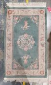 Chinese green ground super wash rug with central medallion and floral border together with a Chinese
