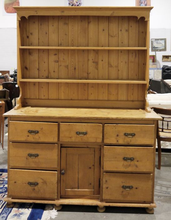 Pine dresser with moulded cornice, two shelves, the base of seven drawers and kennel cupboard